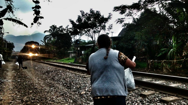 A member of the migrant aid group “Las Patronas” waits for the train known as “The Beast”, that was used by undocumented migrants to cross southern Mexico, to give them water and food. The Mexican government shut down the notorious train in August. Credit: Courtesy of the Mesoamerican Migrant Movement