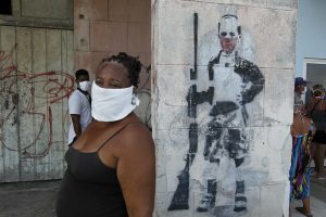 A woman wearing a mask to protect herself from the contagion of the coronavirus, waits to buy food outside a store in the Playa municipality, in Havana, Cuba. As of Tuesday, Jun. 16, 1.7 million people have been affected by the virus across Latin America and the Caribbean -- doubling in the last week. Credit: Jorge Luis Baños / IPS
