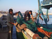 Zaki Al-Habeel (left) prepares his boat. / Credit:Mohammed Omer