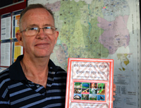 Ron Watt, the education adviser at Care Cambodia, holds a bilingual dictionary used in Care's school programme to revitalise minority languages. / Credit:Robert Carmichael/IPS