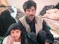 Mukhtar Ahmed, who lost 12 members of his family in the fire, with his sole surviving child. / Credit:Zofeen Ebrahim/IPS