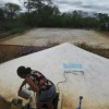 A rural woman in the Northeast takes water from a tank to irrigate her garden.  Credit: Mario Osava/IPS