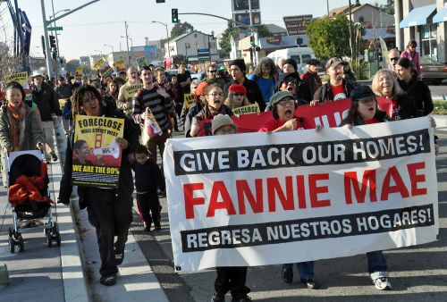 People march through West Oakland to the foreclosed home now owned by Fannie Mae that will be occupied as a community centre. Credit: Judith Scherr/IPS