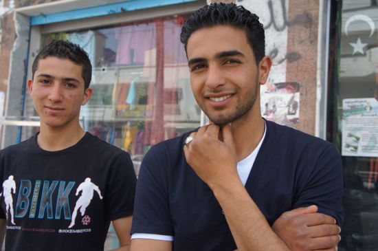 Abdullah Aldiamy (right) outside his family shop at Omar Zerti's occupied building. Credit: Rebecca Murray/IPS.