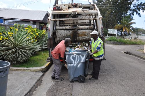 Two men load waste on a truck in St. Kitts. Credit: Desmond Brown/IPS