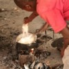 Congolese farmer cooking maize porridge and fish - changing rainfall patterns threaten production of staple foods. Credit:  Miriam Mannak/IPS