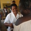 Christina cradles one of her twins while talking to a nurse. Credit:  Ruth Ayisi/IPS