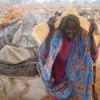 A Darfuri refugee shelters from rain: 'AU member states shall not co-operate... relating to immunities for the arrest and surrender of Sudanese President Omar al-Bashir to the ICC.' Credit:  Claire McEvoy/IRIN