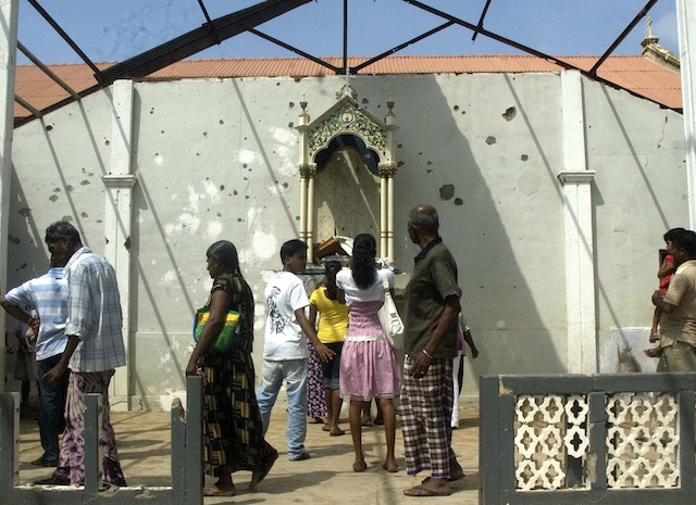 Worshippers gather near the damaged chapel of the Sacred Heart in August 2009, just three months after the war's end. Credit: Courtesy Amantha Perera