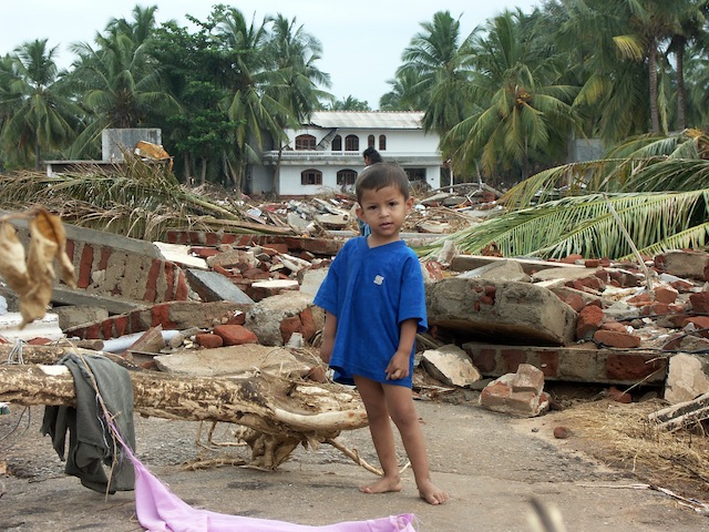A small child stands amidst the destruction in the town of Hambantota, located in southern Sri Lanka. Credit: Amantha Perera/IPS