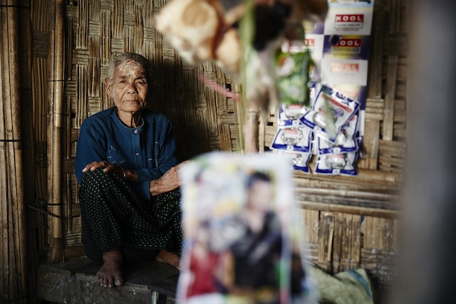 This elderly Rakhine woman has lived through independence and suffered as a member of a repressed minority under authoritarian rule by successive military regimes in Burma. After Rohingya Muslims burned her village in 2012, she has lived in an IDP camp outside Sittwe, where she struggled to save enough money to open this shop. Credit: Courtesy Rob Jarvis