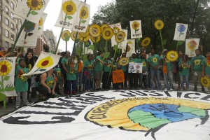 Campaigners at the September 2014 NYC Climate March say, “We need a cooperative model for climate justice.” Credit Roger Hamilton-Martin/IPS
