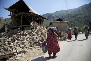 Nepalese people carry UK aid shelter kits back to the remains of their homes, 10 days after the 7.8 magnitude earthquake struck the country on 25 April 2015. Credit: Russell Watkins/DFID