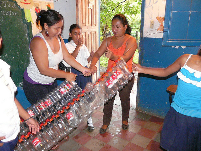 Students and mothers from a school in the city of Altagracia make wastepaper bins using disposable bottles. It is one of the numerous recycling initiatives that have emerged on the island of Ometepe in Nicaragua, inspired by a group of women who organised to collect and process garbage. Credit: Karin Paladino/IPS