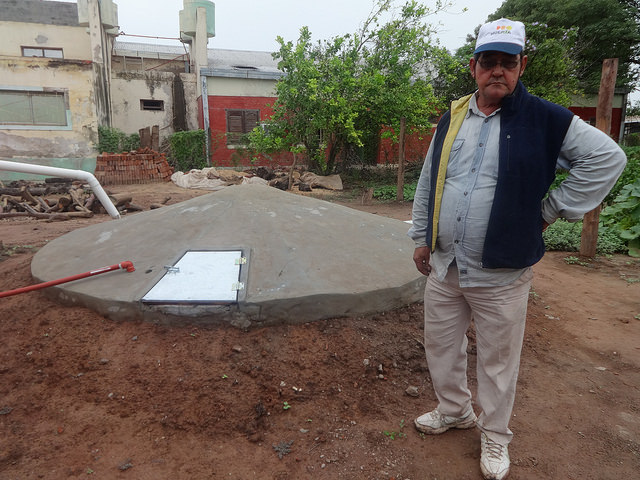 Local small farmer José Ramón Espinoza stands next to a recently constructed community tank for harvesting rainwater, which will enable a group of families to weather the recurrent drought in Corzuela, a rural municipality in the northeast Argentine province of Chaco. The underground tank was provided by GEF’s Small Grants Programme. Credit: Fabiana Frayssinet/IPS