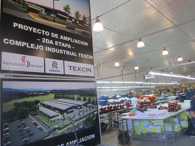 Texcin’s textile warehouse seen behind a sign announcing the expansion of the plant which was built by Brazilian company Riachuelo with partners in Paraguay on the outskirts of Asunción. Credit: Mario Osava/IPS