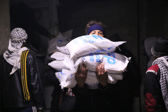 In Madaya, Syria, local community members help offload and distribute humanitarian aid supplies. Photo: WFP/Hussam Al Saleh