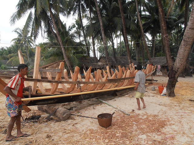 Men build a fishing boat on a beach in Myanmar's Rakhine State. Credit: Guy Dinmore/IPS