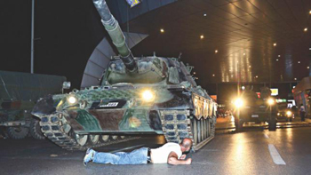 A man lies in front of a Turkish army tank at Ataturk airport in Istanbul. PHOTO: AP