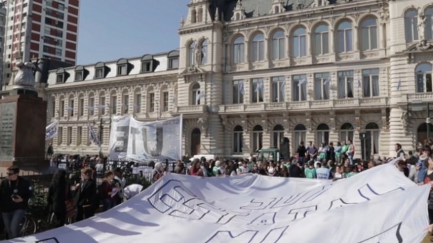 “Hugging” the Ministry of Education in Buenos Aires, teachers and other education workers protest mass redundancies and other changes in a field that has been key until now with regard to inclusion policies. Credit: Guido Fontán/IPS