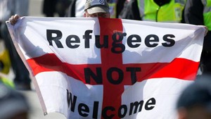 A demonstrator holds up an anti-immigration flag during a demonstration by far-right protesters in Dover, U.K. on May 28, 2016. PHOTO: AFP