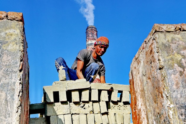 A worker arranges bricks for burning at a traditional brick factory in Munshiganj, Bangladesh. Such factories are responsible for a large amount of carbon emissions. Credit: Farid Ahmed/IPS