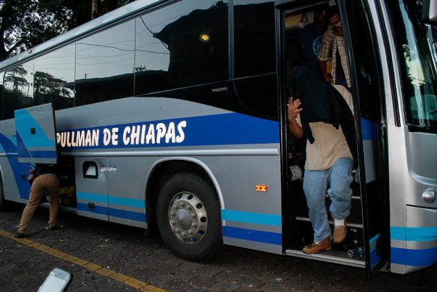 Salvadorans deported from Mexico reach the migrants assistance office in the Salvadoran capital, where they talk to local officials. Due to the stigma given the popular belief that they have been deported for committing crimes, many cover their faces as they get off the bus. Credit: Edgardo Ayala/IPS