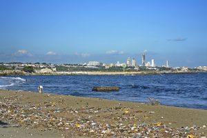 A man combs through objects among the trash strewn on the polluted sands of El Gringo beach in the city of Bajos de Haina, the Dominican Republic’s main industrial centre and port. Credit: Jorge Luis Bolaños/IPS