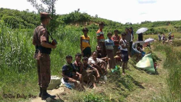A BGB soldier stands guard near some Rohingya refugees at Ghumdhum in Naikhyangchhari upazila of Bandarban on August 27, 2017. Photo: Anisur Rahman