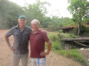 Brothers Daniel (left) and Armando Schlindewein stand in front of the small bridge over the Matrinxã river which will be submerged by the filling of the Sinop hydropower dam reservoir in western Brazil. Since the house they share is on the other side of the river, they will have to move, and their farms, which are connected by the bridge, will be separated. Credit: Mario Osava/IPS