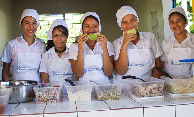 Students of the Pepenance District School in the municipality of Atiquizaya, in western El Salvador, pose for pictures in front of one of the nutritious daily meals offered to the students, which are made with products from local farmers. Credit: Edgardo Ayala / IPS