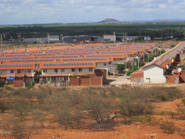 The social housing complexes of Morada do Salitre and Praia do Rodeadouro, with solar panels on their rooftops, make up a village of 1,000 families on the outskirts of the city of Juazeiro, in the Brazilian state of Bahia. A solar energy project, which has been suspended, created jobs for local residents to plant trees and clean the streets. Credit: Mario Osava/IPS