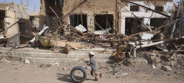 Peace “Only Way Forward” For Yemen - A young boy runs with his tyre past buildings damaged by airstrikes in Saada Old Town. UNICEF says health facilities in the country have been cut by more than half, thousands of schools have been destroyed, and over 2,000 children have been killed. Credit: Giles Clarke/OCHA