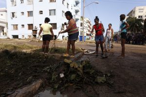 A group of women clean a street after the passage of Hurricane Irma, in the Havana neighborhood of Vedado in September 2017. Women play a leading role in mitigating the impacts of climate change, a phenomenon to which they are also the most vulnerable. Credit: Jorge Luis Baños/IPS