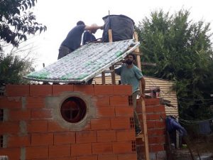 Volunteers install a solar water heater, made from recycled materials, with a 90-litre tank on the roof of a modest home in the Argentine municipality of Pilar, 50 km north of Buenos Aires. This unique thermal generation system was designed by Brazilian engineer José Alano, who did not patent it in order to facilitate its free use. Credit: Daniel Gutman/IPS