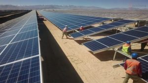Employees work on the solar panels of the El Romero plant, with a capacity of 196 megawatts, in the desert region of Atacama in northern Chile, a country that has set out to develop its solar power potential. CREDIT: Acciona