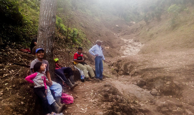 Farmers take a break from their work to reopen a road blocked by a mudslide that came down from the top of El Picacho mountain, next to the crater of the San Salvador volcano. The Oct. 29 landslide claimed nine lives, left one person missing and caused extensive material damage. CREDIT: Edgardo Ayala/IPS