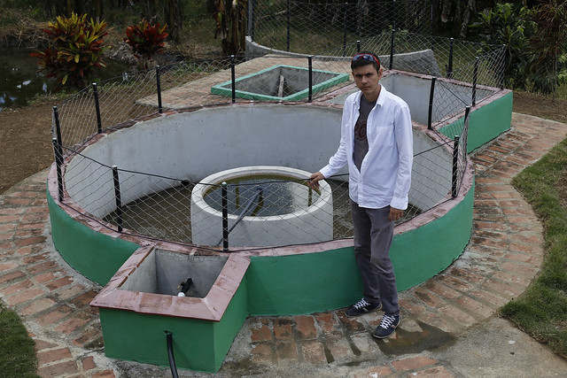  Engineer Alexander López Savrán stands next to one of the standard fixed-dome biodigesters he has developed, installed on a farm in La Macuca, a village in the municipality of Cabaiguán, in the central province of Santi Spíritus, Cuba. CREDIT: Jorge Luis Baños/IPS