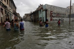 Local residents stand in the water on a street flooded by the sea in the Centro Habana municipality in the Cuban capital in September 2017 in the wake of Hurricane Irma, one of the most intense storms in recent decades in this Caribbean island nation. CREDIT: Jorge Luis Baños/IPS