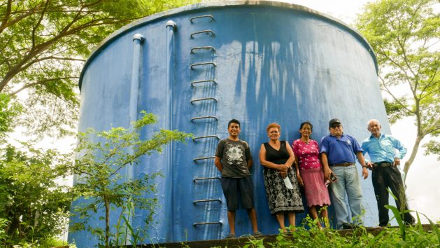 Members of the Cangrejera Drinking Water Association in the Desvío de Amayo village, La Libertad municipality in central El Salvador, stand at the foot of the tank from which water flows by gravity to the nine villages that benefit from this community project. There are an estimated 2,500 rural water boards in the country, which provide service to 1.6 million people. CREDIT: Edgardo Ayala/IPS