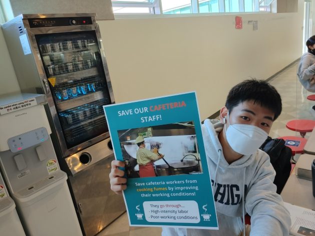 Soo Hyoun Lim's classmate doing a campaign inside the Yongsan International SchoolÃ¢Â€Â™s cafeteria with the poster.