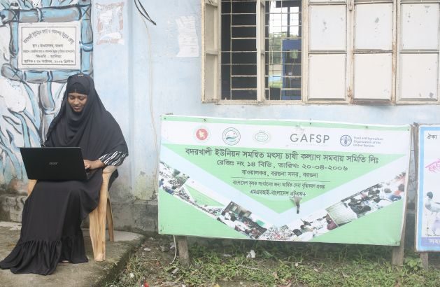 Laboni Akhter works on a laptop in front of the digital service centre at Bawalkar village in Badarkhali, Barguna district, southern Bangladesh, in September 2022. Credit: Farid Ahmed/IPS