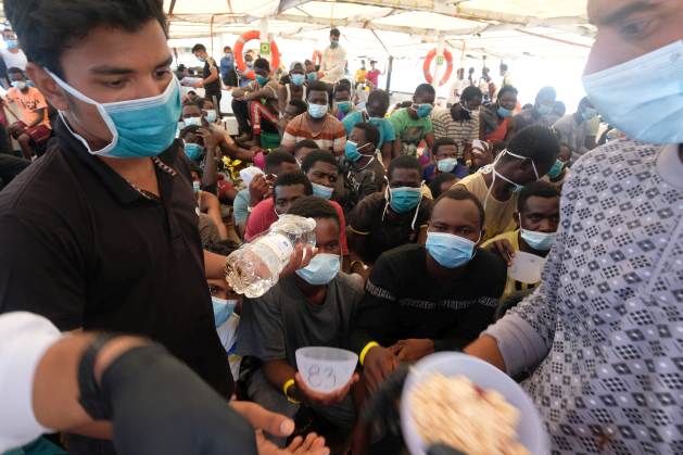 Lunchtime aboard the crowded deck of the Open Arms. Delays in granting a safe harbour only contribute to the exhaustion of those rescued. Credit: Karlos Zurutuza / IPS