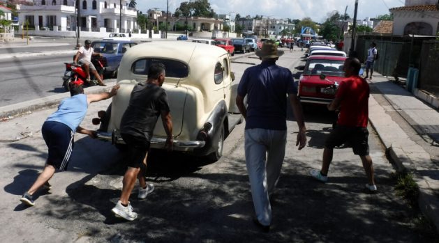 A group of drivers push a car at the end of a long line to refuel in Havana. The Cuban authorities say the fundamental cause of the shortage of diesel and gasoline has to do with breaches of contracts by suppliers. CREDIT: Jorge Luis Baños/IPS