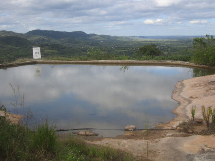 A "stone tank" that takes advantage of holes in the rocks to store rainwater is one of the technologies used to coexist with the scarcity of rainfall in Brazil's semiarid Northeast ecoregion. In the background can be seen the mountainous landscape of the Sertão de Pajeú, in northeastern Brazil. CREDIT: Mario Osava / IPS