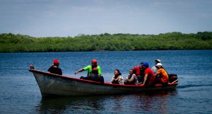 A group of "curileros" ride in a boat in the bay of Jiquilisco, in the Pacific Ocean off the Salvadoran coast, during the daily task of searching for "curiles", a locally prized mollusk. Two municipalities bordering the bay, Jiquilisco and Puerto El Triunfo, are working to keep a treatment plant that processes wastewater from these towns active, in order to avoid contaminating this important wetland and protect the health of local families and visitors. CREDIT: Edgardo Ayala / IPS