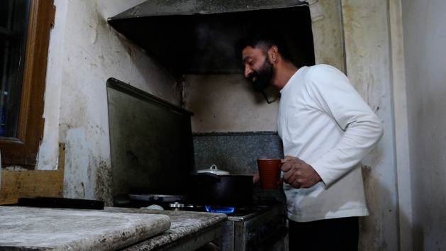 An Indian man prepares a meal in the kitchen of his apartment in Yerevan, Armenia, shared with fellow Indians. Typically, they head out for labor work early in the morning, returning around 8 pm. Credit: Lilit Gasparyan/IPS