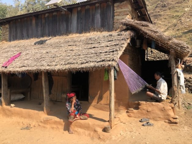 Kul Bahadur Pulami Magar at his home in Majhitar village in Dhading, knitting a fishing net. While weaving to create the fishing net, he shared his anguish about how winter drought affected his family. Credit: Tanka Dhakal/IPS