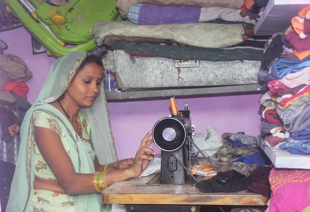 Nimaben Harishbhai works at her sewing machine in her tiny 8x4-square-foot sewing room behind her home in an Ahmedabad slum. Credit: Manipadma Jena/IPS