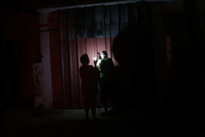 Two people use the flashlight of a cell phone during a blackout in Havana. The government hopes that, from the current five percent, renewable sources will account for around 30 percent of electricity generation by 2030, in order to strengthen national energy security. CREDIT: Jorge Luis Baños / IPS